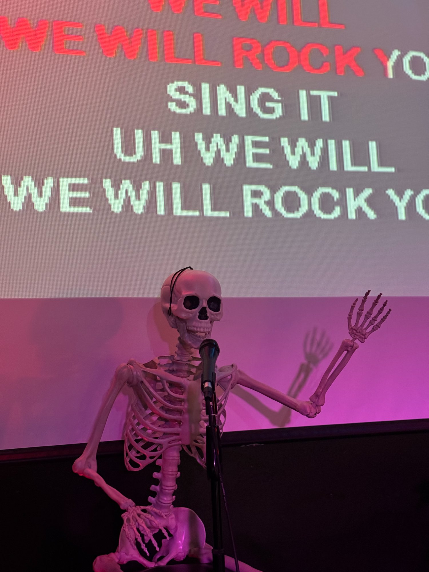 Skeleton prop singing We Will Rock You karaoke