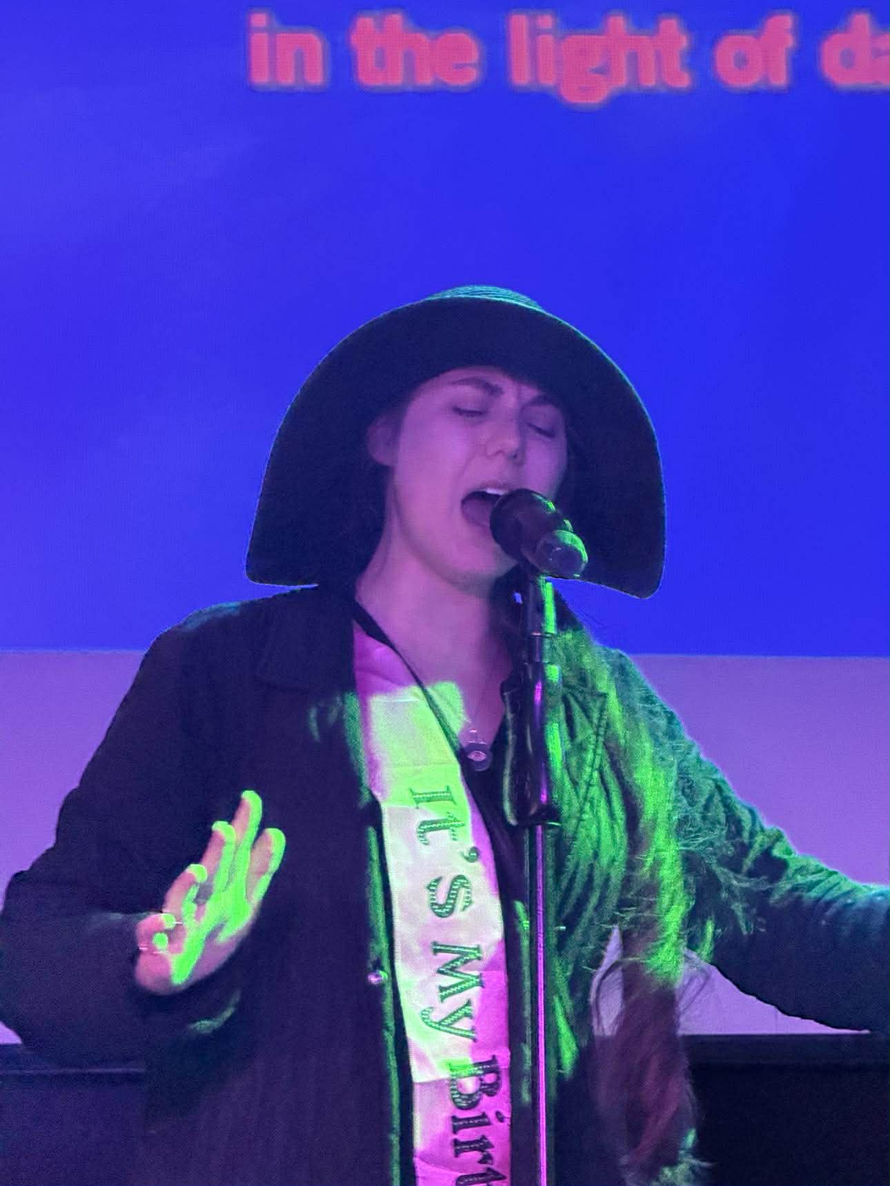 Guest singing karaoke under stage lights
